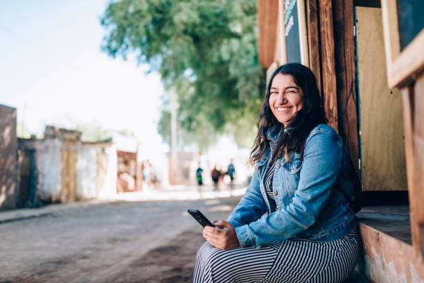 istock Young Chilean woman using cell phone on the streets 1398236718