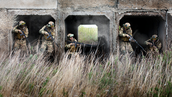 Five special forces soldiers during a special operation at the exit from the tunnel. Collage - one model in five poses.