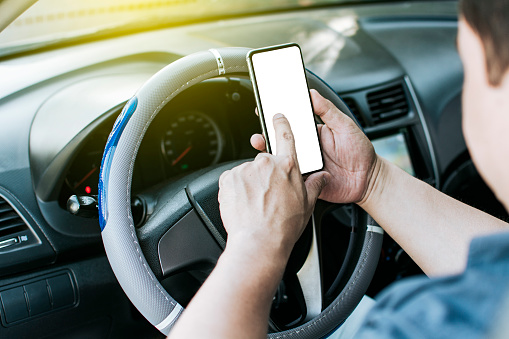 Close up of driver hands using his phone, Person in his car using cell phone, Concept driver hands touching cell phone screen