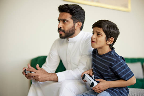 istock Saudi father and son competing during video game 1398245697