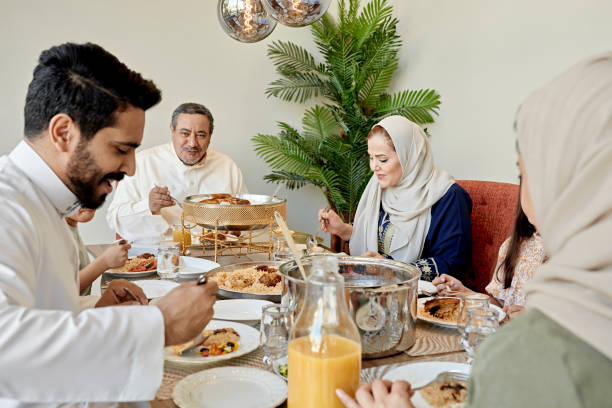família do oriente médio multigera que desfruta de refeição - saudi arabia child ramadan offspring - fotografias e filmes do acervo