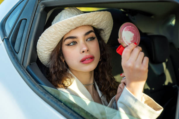 mulher bonita fazendo maquiagem no carro - rear view mirror car mirror sun - fotografias e filmes do acervo