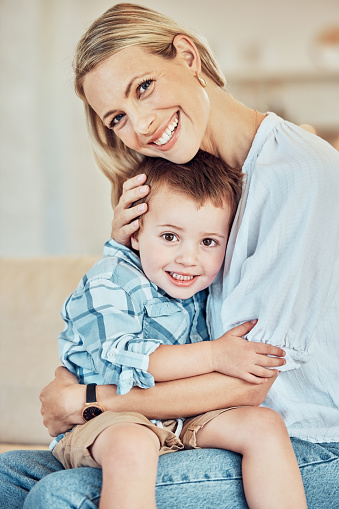 Portrait of a beautiful young woman and little son. Caucasian woman embracing her adorable child. Small boy being affectionate with his parent. Loving woman hugging her kid, bond of a mother's love