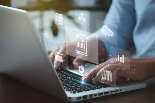 Photo of document management concept with icons on virtual screen, ERPBusinessman working on the computer for document management concept, online documentation database, and digital file storage system.