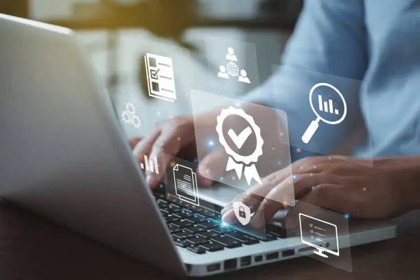 Photo of Businessman working on laptops with signs of the top service Quality control certification checked guarantees of the standard of company product. Concept on virtual screen.