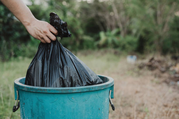 istock hand holding a garbage bag and is dropping into the trash. 1398248196