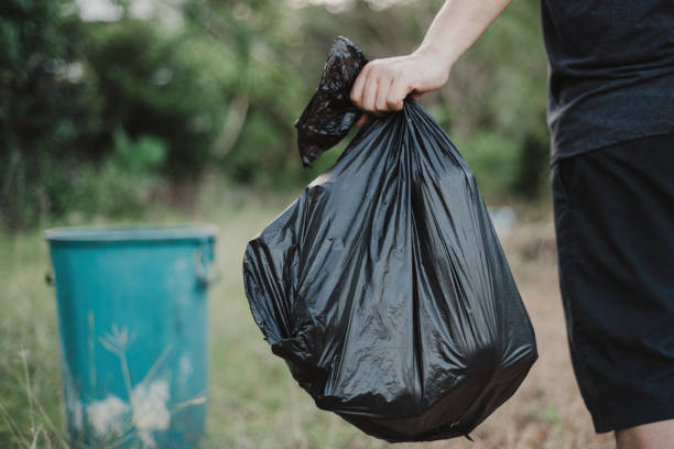 istock hand holding a garbage bag and are being dropped into the trash. 1398248373