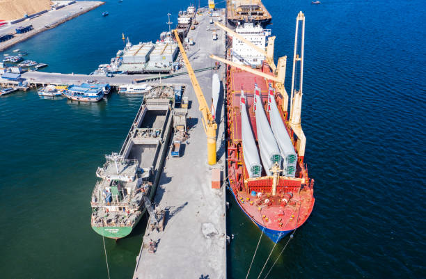 istock Container ship at industrial port in business logistic export import concept. Containers and wind turbine parts in cargo freight ship with industrial crane. 1398249117