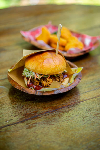 istock A large hamburger is placed on a wooden table. 1398249305