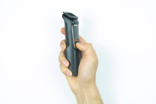 istock Man hand holding a black shaving machine, isolated on white background, front view of a wireless electric razor, shave and barber idea 1398249503