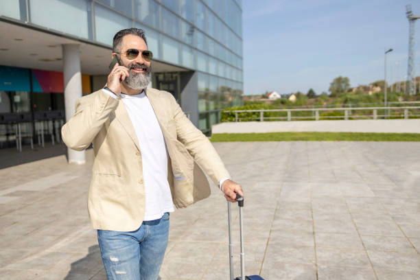 istock Businessman having phone conversation when leaving airport 1398249546