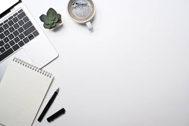 istock Minimal workplace with laptop computer, coffee cup, blank notepad and succulent plant. Top view with copy space. 1398251380