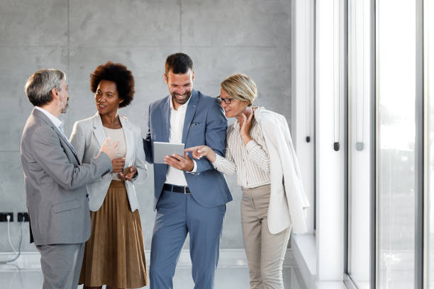 istock Team of happy business colleagues talking while using touchpad in the office. 1398255470