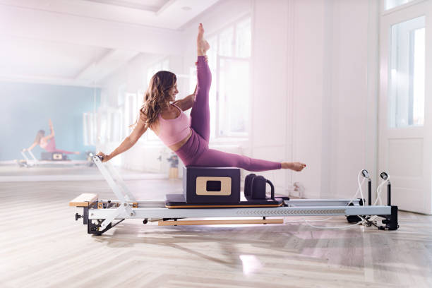 istock Happy athletic woman stretching on a Pilates machine. 1398256785