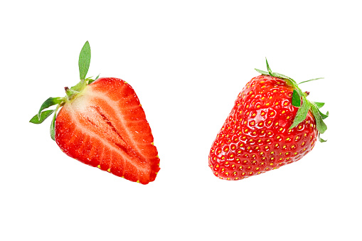 half and whole red strawberry isolated on white background.