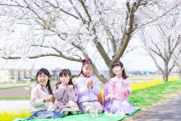 istock Little girls having a picnic under a cherry tree 1398258032