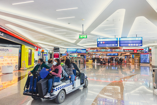 Passengers taking a ride to their departure gate using shuttle service at Dubai International Airport Terminal.