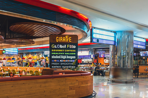 Dubai, UAE - April 27 2020: Image of a multi cuisine restaurant at Dubai International Airport Terminal. Dubai International departure terminal is one of the most busiest airports in the world. The airport terminal has all the required modern amenities such as restaurants, retail space, gaming arcades, prayer rooms, relaxation facilities such as spa, hotels.
