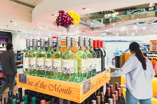 Dubai, UAE - April 27 2020: Passengers exploring wine and liquor section of Dubai Duty Free retail store at Dubai International Airport Terminal. The airport terminal also has all the required modern amenities such as restaurants, gaming arcades, prayer rooms, relaxation facilities such as spa and hotels.