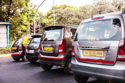 Taxi, Private Cars, Uber, various cars stopped at the traffic signal. Mumbai, India