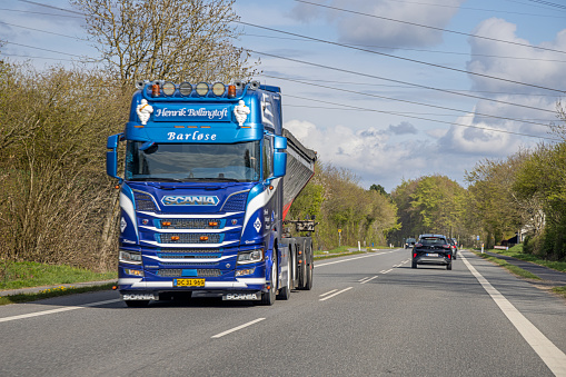 Heavy blue truck on a two lane road crossing the Danish island Funen