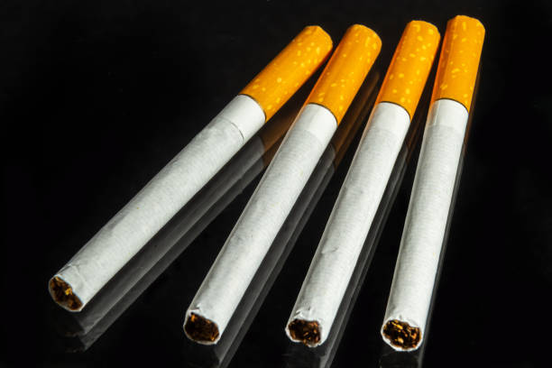 istock some white and brown cigarettes, cigarettes allowed only for over eighteen, black background 1398260447