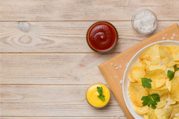 istock Top view chips with sause in bowl on colored background, top view with copy space 1398262103