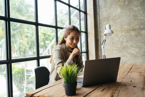 istock A beautiful young asian business woman using laptop computer while working in office 1398264169