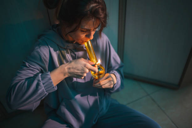 Woman smoking pot using bong stock photo