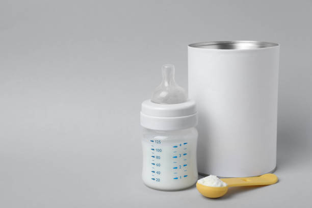 Blank can of powdered infant formula with scoop and feeding bottle on light grey background, space for text. Baby milk Blank can of powdered infant formula with scoop and feeding bottle on light grey background, space for text. Baby milk formula stock pictures, royalty-free photos & images