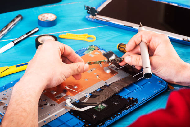 istock Wizard repairs laptop with tools and hands on the blue wooding table. top view 1398267188