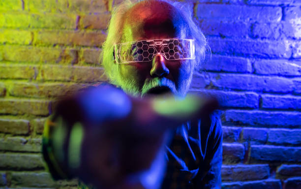 istock Asian old man having fun playing with innovative virtual reality goggles fighting sport against virtual opponent 1398267230