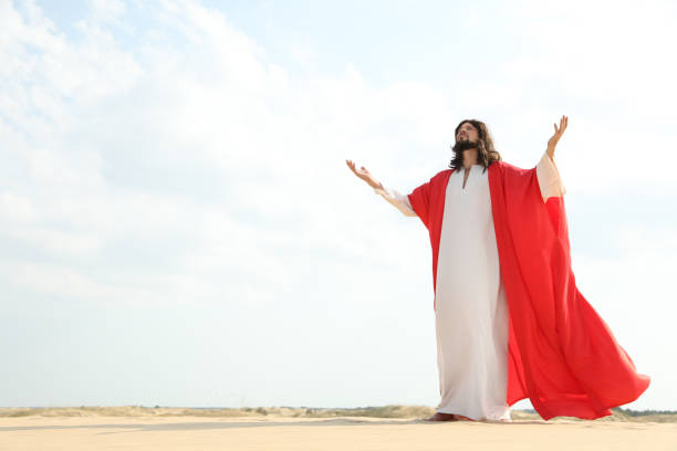 istock Jesus Christ raising hands in desert. Space for text 1398267418
