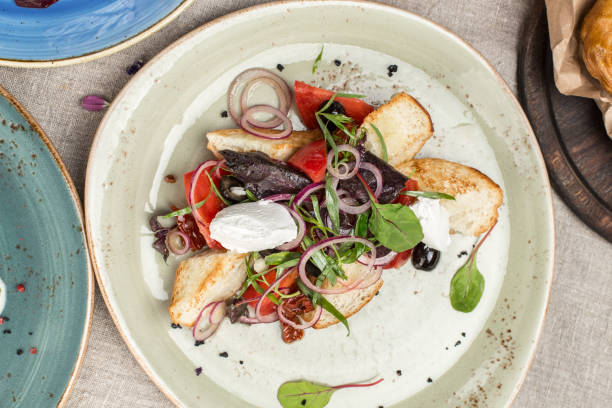 istock salad with fresh tomatoes, basil, cream cheese and toasted bread on the table at restaurant 1398267977
