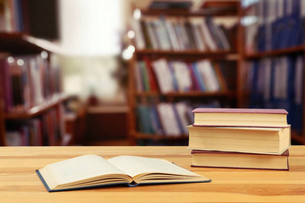 istock Many books on wooden table in library 1398268371