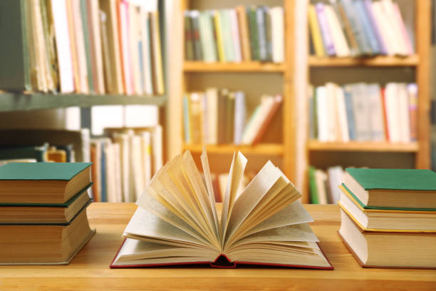 istock Many books on wooden table in library 1398268417