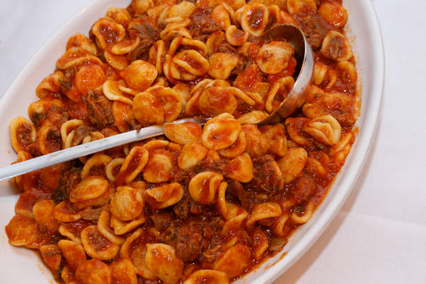 orecchiette di pasta del sud italia con salsa di pomodoro e ragù di carne macinata - orecchiette foto e immagini stock