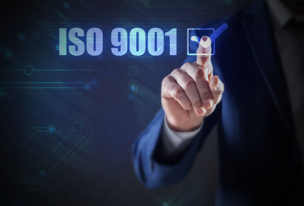 istock Man pointing at virtual screen with text ISO 9001, closeup 1398269905