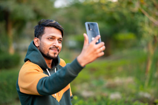 istock Handsome Indian Man Taking Selfie With Mobile Phone in park 1398273142