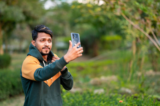 istock Handsome Indian Man Taking Selfie With Mobile Phone in park 1398273155