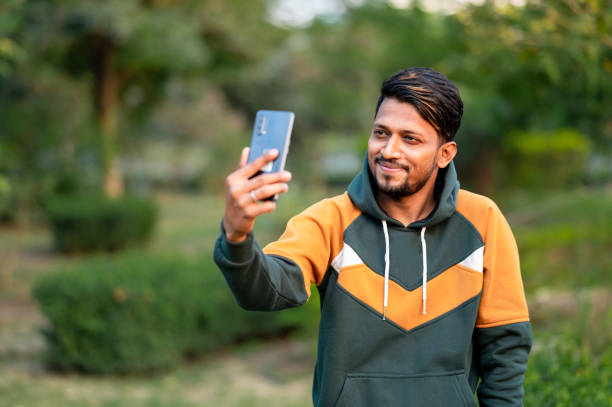 Handsome Indian Man Taking Selfie With Mobile Phone in park