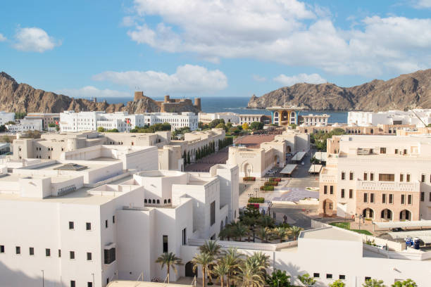 Muttrah, Muscat, Oman: the corniche - Al Bahri Road, facing the Gulf of Oman / Arabian sea - two Sultan / government owned super yachts moored at Sultan Qaboos Port - Al Hajar Mountains in the background.