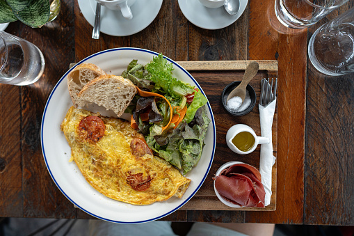 High angle view of plate with egg omelette, salad and bread
