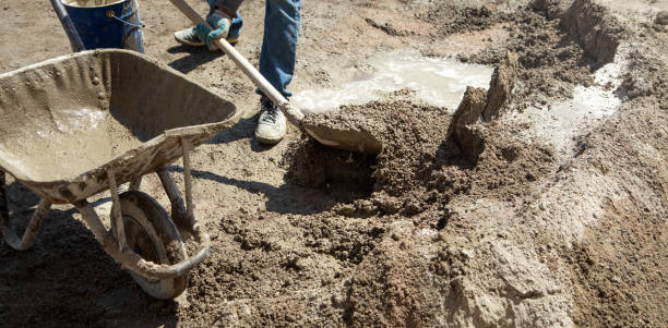 istock Worker prepare concrete with shovel at construction site. 1398278194