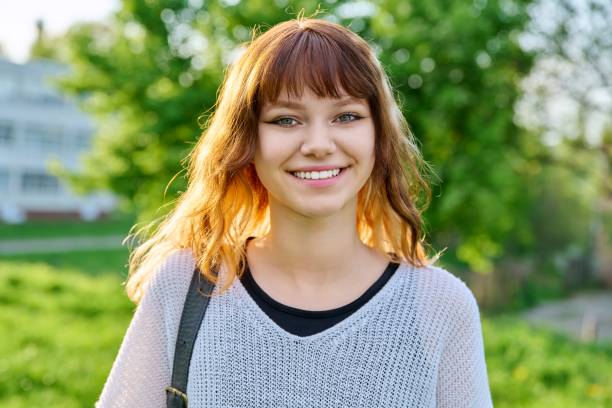 카메라를 바라보는 배낭을 가진 아름다운 미소 짓는 십대 여학생의 야외 초상화 - beautiful student female beauty in nature 뉴스 사진 이미지