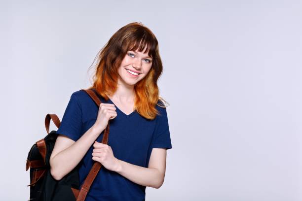 istock Positive redhead teenage female student with backpack looking at camera 1398279614