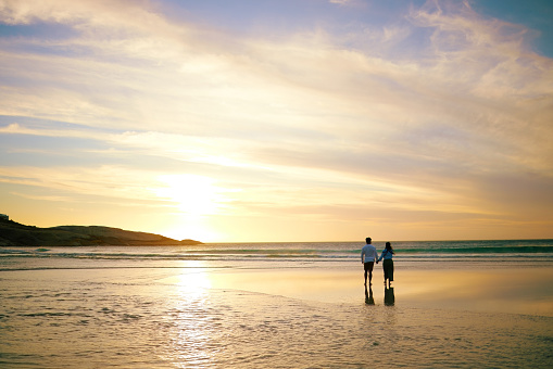 istock Rearview shot of an unrecongnizable couple enjoying a romantic walk at the beach 1398279739