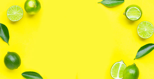 istock Fresh limes with leaves on yellow background. 1398279753