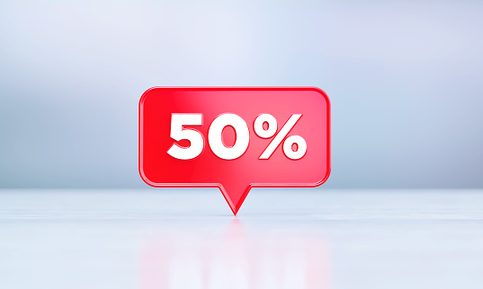 50 percent off written red speech bubble sitting on before silver defocused background. Horizontal composition with copy space.