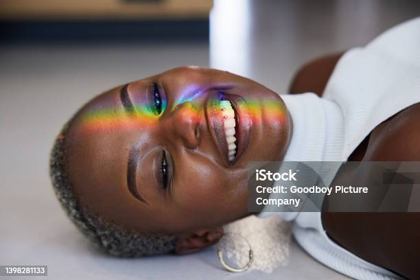Rainbow Colored Light Refracting Onto The Face Of A Smiling Woman Stock Photo - Download Image Now